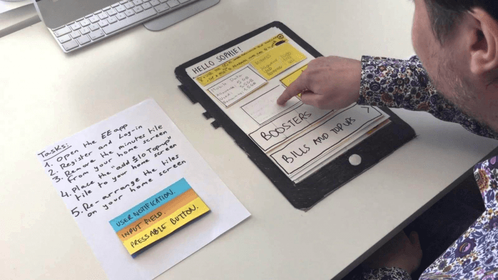  Man touching paper which shows mock application layout