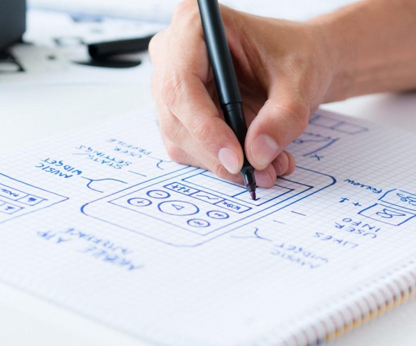 Designer develop a mobile application usability and drawing its framework on a paper.