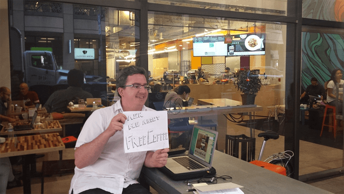  Photo of man holding up sign that reads 