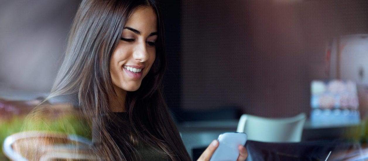 Woman looking at her phone similing