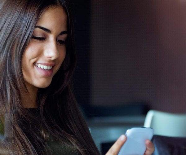 Woman looking at her phone similing