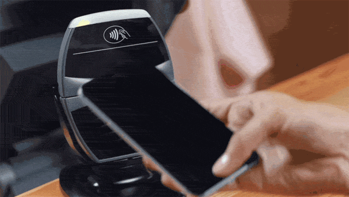 Person paying with an iPhone using Touch ID