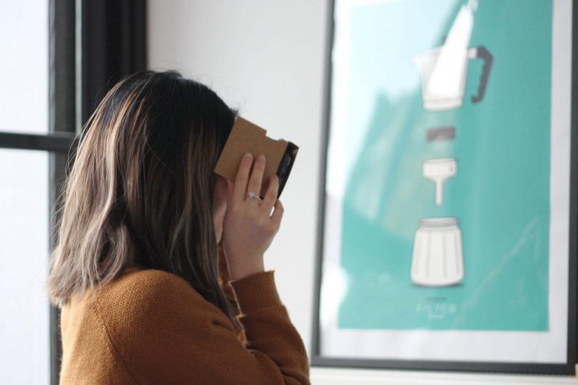 Woman using Google's cardboard VR headset.