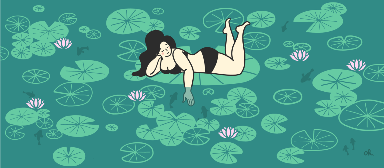 Woman in a two piece bathing suit is laying on an lilypond.