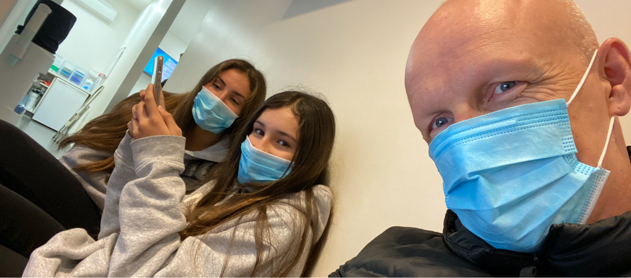 Guy Ligertwood and his daughters don face masks.