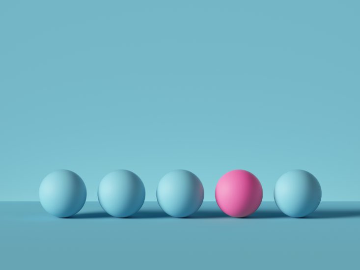 Image of five 3D spheres in a row, the 4th a different color than the rest. 
