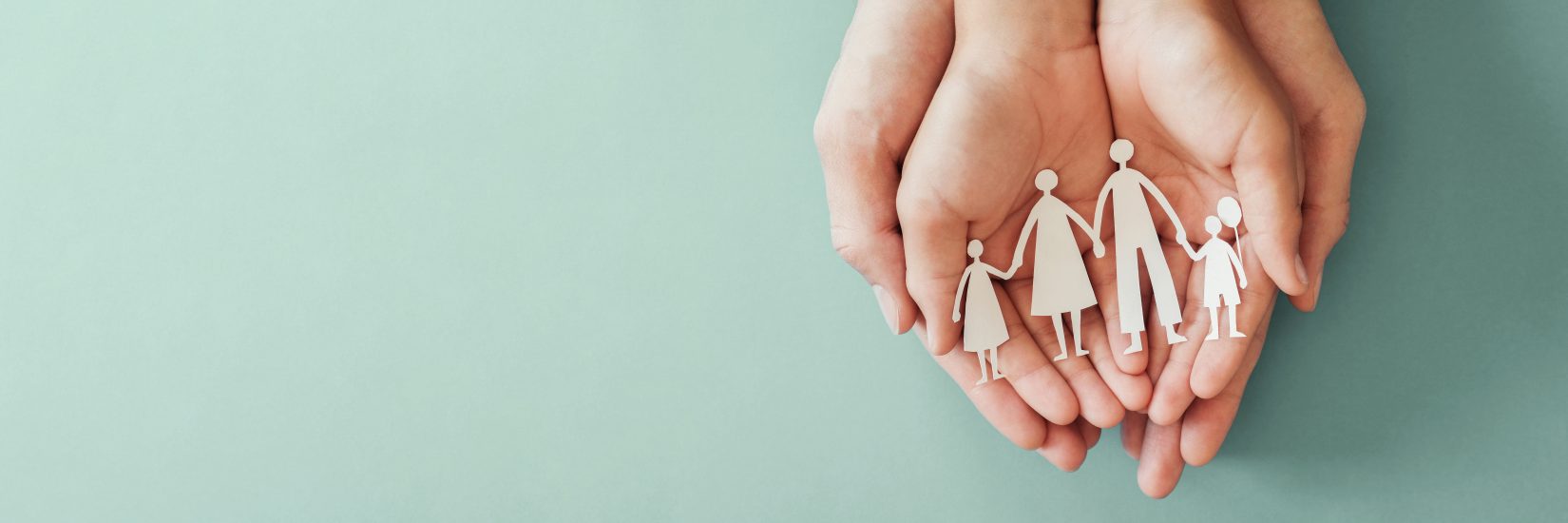 Hands holding paper family cutout.