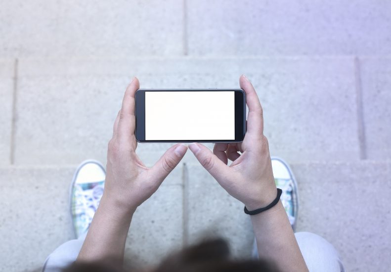 Overhead view of a user looking down at a smart phone.