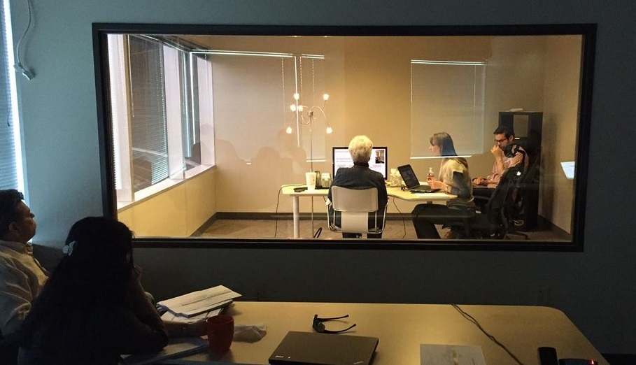 A moderated usability test is conducted in a room with 2 interviewers and one participant while 2 observers watch behind a 1-way mirror.